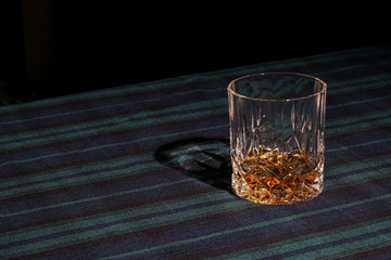 A glass of whisky on tartan
