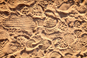 Full frame background of footprints in soft red sand and dirt