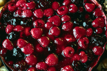 Berry pie on the Christmas table. Still life on a new year's theme, berries, tree branches, cones, Christmas toys and garlands.