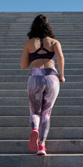 Young woman in sportswear doing sports, running up the stairs