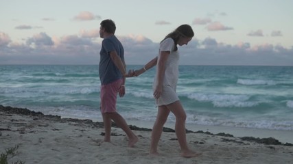 A couple in love says goodbye and diverges in different directions against the backdrop of the ocean