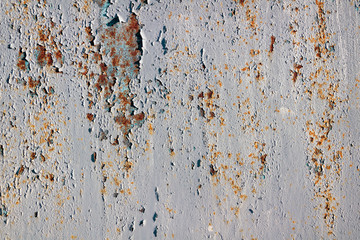 Peeling paint on a rusty metal surface.