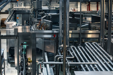 Industrial background of beer factory or plant production with computerized automation process, stainless steel vats, reservoirs, pipelines, tubes and modern robotized technologies and electronics