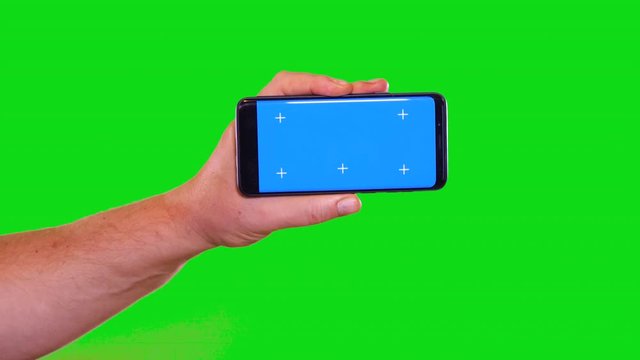 Horizontal blue screen cell phone with green background male hand swipe to the right