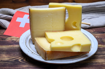 Cheese collection, swiss emmentaler, Gruyere, appenzeller cheeses and flag of Switzerland
