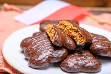 Tasty gingerbread glazed cookies from Torun, Poland and flag of Poland