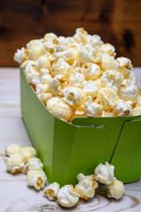 Green paper box with sweet popcorn ready to eat