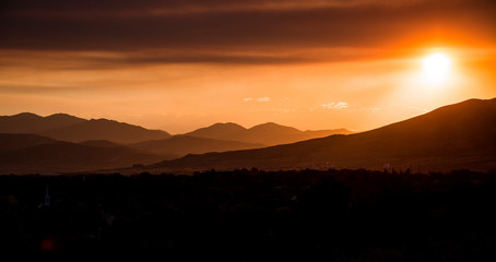 Wildfire smoke obscures the sun and creates an eerie mood at sunset.