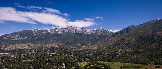 An aerial drone shot captures Lone Peak Mountain and Alpine Utah on a sunny summer day. 