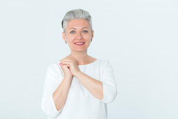 Portrait of a happy mature woman standing on a light background..Female middle age.