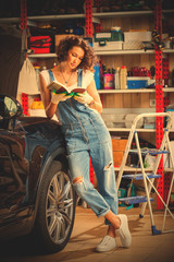 woman in blue overalls studying the instructions for vehicle adjustment