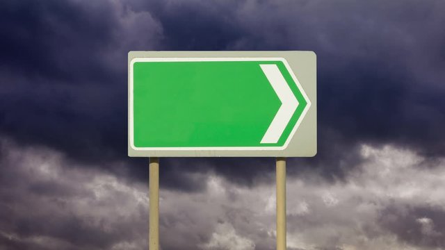 A blank directional road sign with a background of time lapse gathering dark storm clouds. Going no where. Going to an empty future. Going to a stormy and unsettled future.