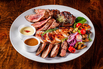 Turkish cuisine. Assorted different meat on the grill, lamb, chicken, pork with grilled vegetables....