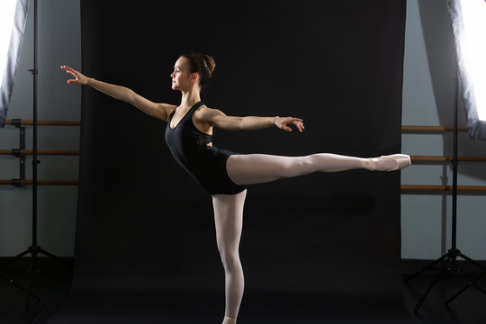 Ballet dancer poses as photo is taken with studio lights