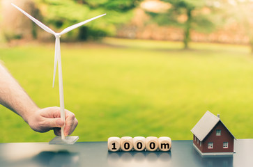 Symbol for a minimum gap of 1000 meter between wind turbines and residential areas.