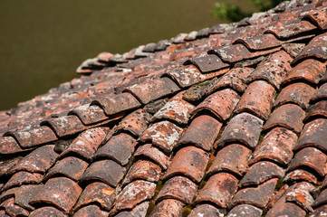 Old vintage red ceramic roof tiles closeup as background