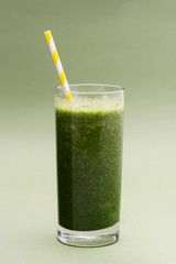 Blended green smoothie glass selective focus, green background. Healthy food.