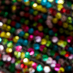 Intentional blur of bright and colorful sequin background reflecting light; Rainbow colors of glittering sequins
