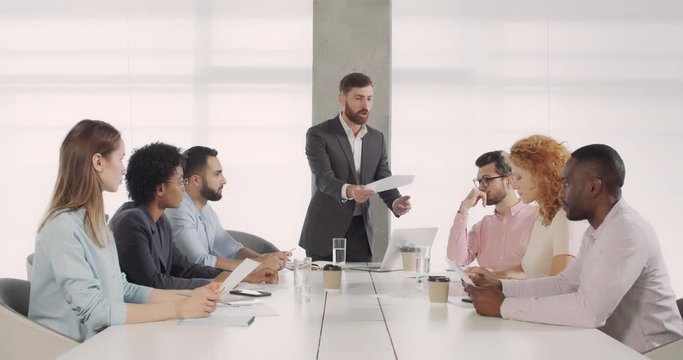 Angry male ceo talking to multiethnic workers.