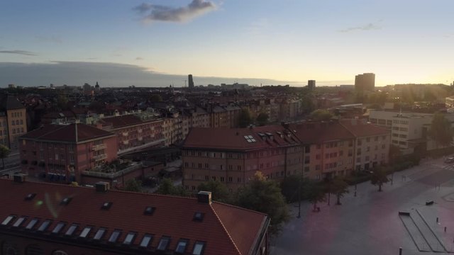 Drone shot flying up over Stockholm city buildings and Stockholm East Train Station at sunset. Aerial view of Stockholm cityscape skyline downtown and Stockholms &ouml;stra station, Capital of Sweden