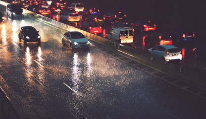 car traffic by city highway in rainy night