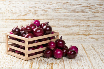 fresh raw onions in a wooden box. red raw onions in a wooden box.