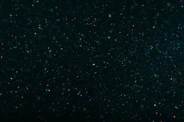 multi-colored crystalline particles, flickering magic dust on black background