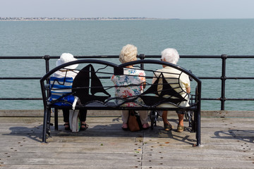 Three senior women sitting on bench