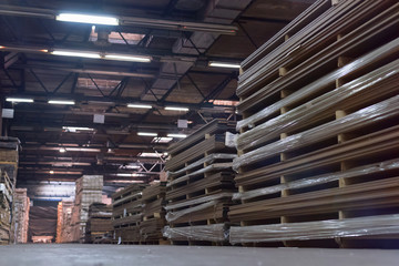 Timber Flooring Factory. Pile of cut wood in factory storage warehouse. Lumber in warehouse.