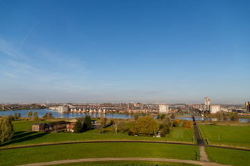 Skyline from vinex neighbourhood Barendrecht Carnisselande and Rotterdam at the background, taken from â€œGaatkensbultâ€ with a blue sky.