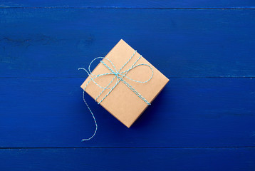 brown cardboard gift square box on a blue wooden background