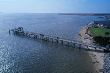 Fototapeta premium Aerial view of the Southport NC water front. Looking down the shoreline. The mouth of the cape fear river enters the atlantic ocean.