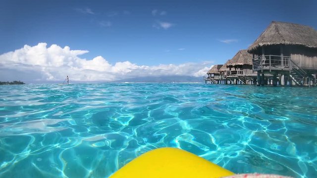 Standup pedaling, kayak in turquoise lagoon. Moorea, Tahiti French Polynesia. Luxury travel vacation & paradise getaway, romantic honeymoon exotic destination.  