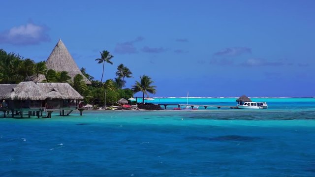 Low angle drone shot of overwater bungalow villas in turquoise lagoon. Bora Bora, Tahiti French Polynesia. Paradise travel vacation & romantic getaway, honeymoon exotic destination.