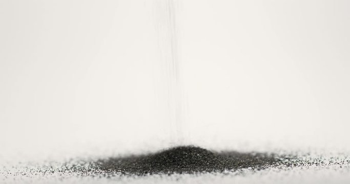 Pouring black volcanic soil on white isolated background