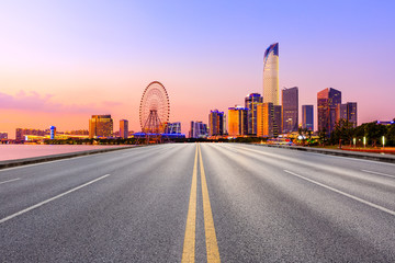 Fototapeta na wymiar Empty asphalt highway and Suzhou city skyline with beautiful colorful sky at sunset.