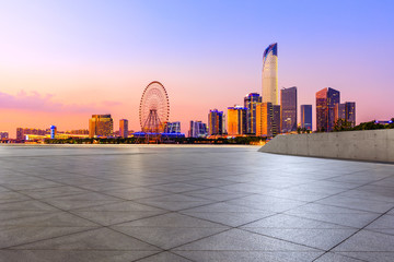 Empty square floor and modern city skyline with buildings in suzhou at night,China.