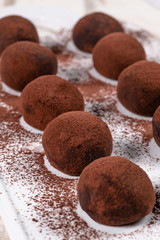 Fototapeta na wymiar Fine chocolate truffles on white ceramic plate.