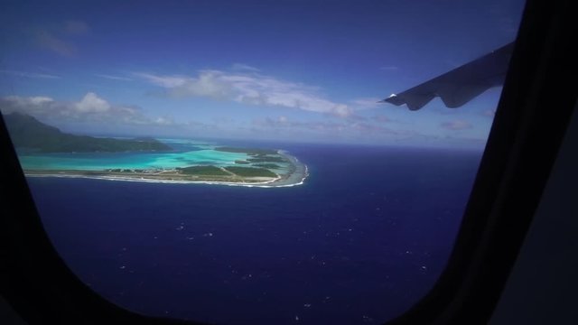 Airplane window view of turquoise blue lagoon in Bora Bora island, Tahiti, French Polynesia. Luxury travel vacation & romantic getaway, honeymoon exotic destination. 