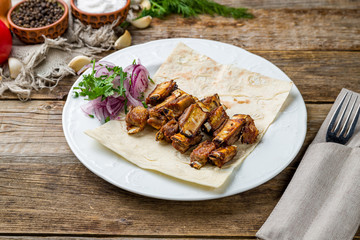Kebab from lamb ribs on wooden table