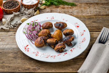 Skewers of mushrooms on wooden table