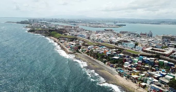 Cinematic Aerial of San Juan, Puerto Rico. Colorful La Perla Neighborhood, Castillo San Cristobal and Atlantic Ocean Coast