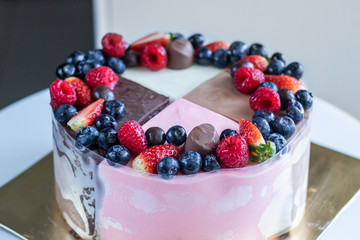 Four seasons Cake with berries and candies on a golden backing.