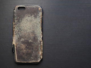 Very old mobile phone case on dark background. Copy space..
