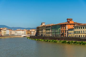 Fototapeta na wymiar Traditional colorful ancient Italian architecture houses in Pisa, Italy, alongside the embankment of Arno river