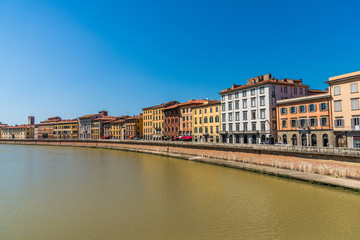 Naklejka na ściany i meble Traditional colorful ancient Italian architecture houses in Pisa, Italy, alongside the embankment of Arno river