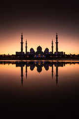 Sheikh Zayed Grand Mosque with its reflection shortly after sunset. Abu Dhabi, United Arab Emirates.