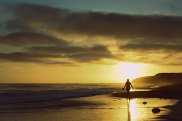 Person Walking along Sunset Beach