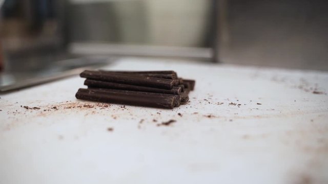 Placing a handful of chocolate batons on a cutting board. This was taken at a higher frame rate and has been converted to a slow motion video clip.
