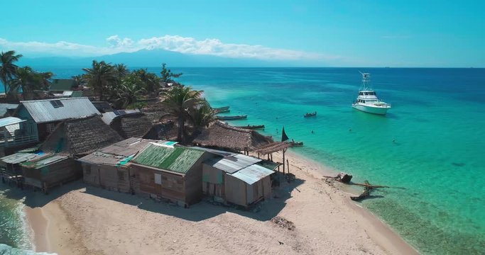 Aerial over tropical waters, rotating around small island homes of Cayos Cochinos, Roatan